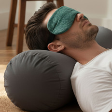 Mann mit Augenmaske und Kissen Ein Mann liegt mit Augenmaske auf einem Kissen