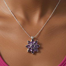 Kette mit lilafarbenem Blumenanhänger Nahaufnahme einer Silberschmuckkette mit einem lilafarbenen Blumenanhänger