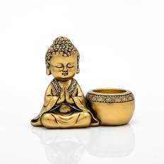Goldene Buddha-Figur mit Gebetsschale Goldene Buddha-Figur im Gebet neben einer dekorativen Schale