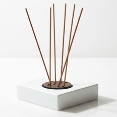 Raumduftstäbchen in schlichtem Halter Mehrere Duftstäbchen in einem modernen, weißen Halter arrangiert.
