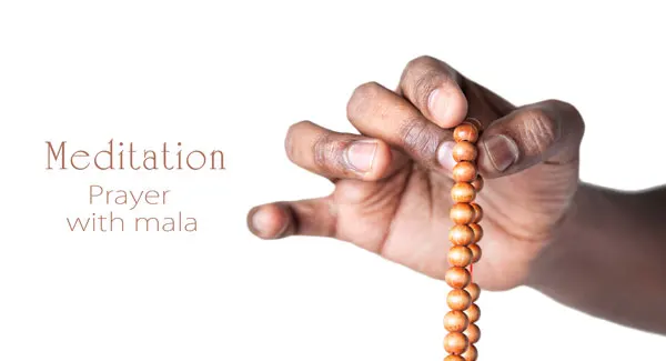 Hand mit Mala Kette für Meditation und Gebet