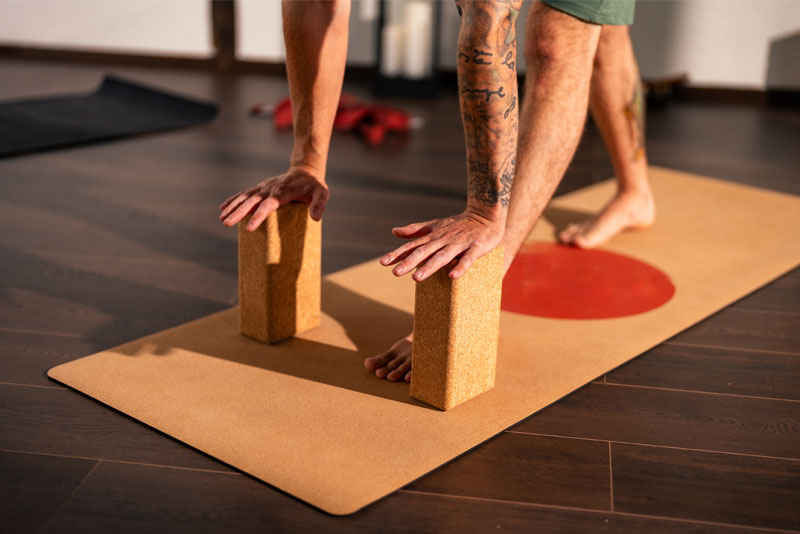 Yogini nutzt den Yogablock Kork in Trikonasana