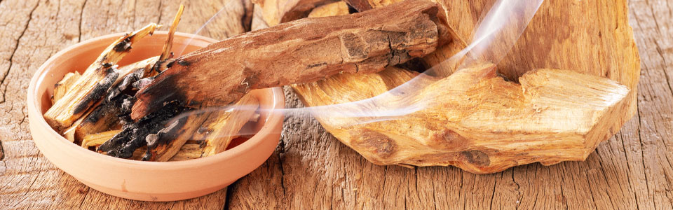 Palo Santo Holz und Rauch auf rustikalem Holzuntergrund