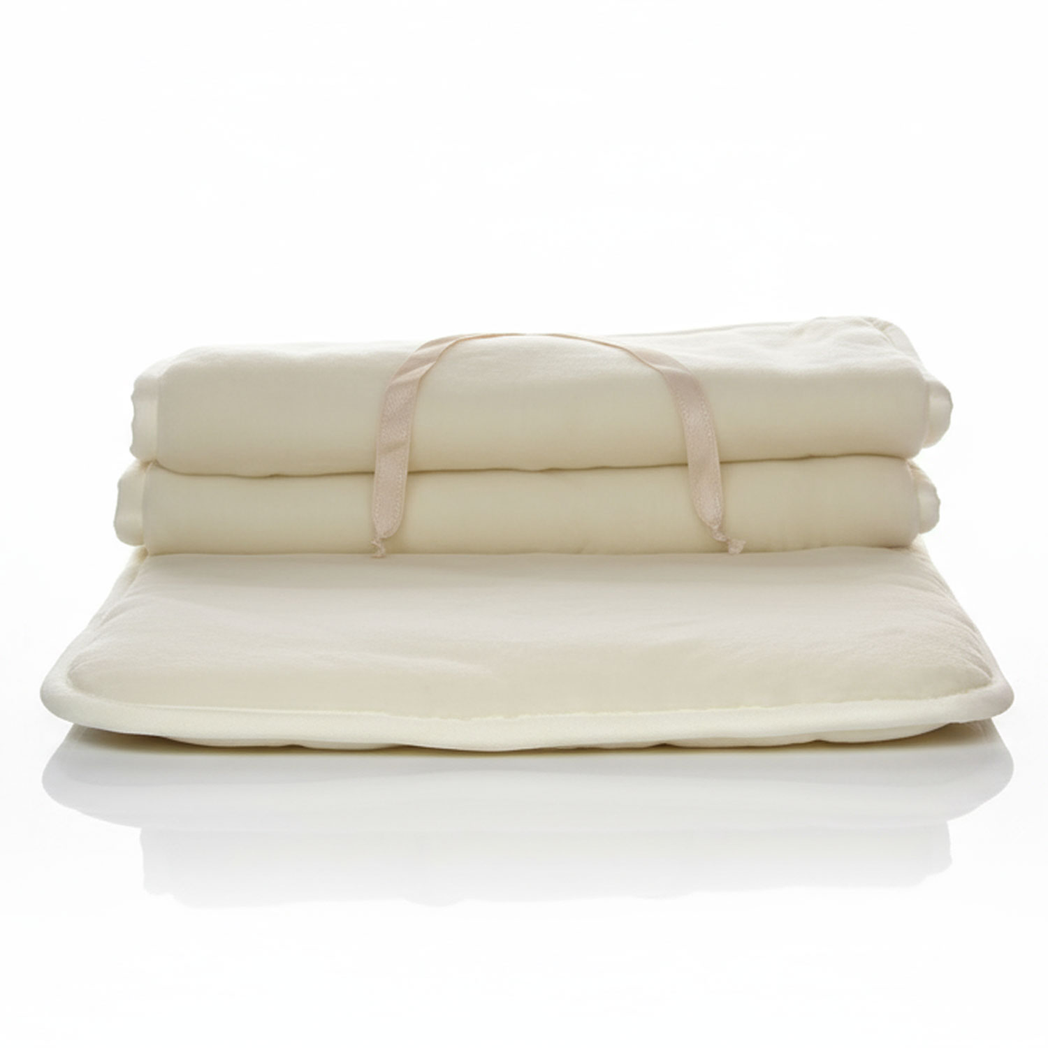 Zwei zusammengelegte beige Decken mit einem Griff auf einem Spiegelboden