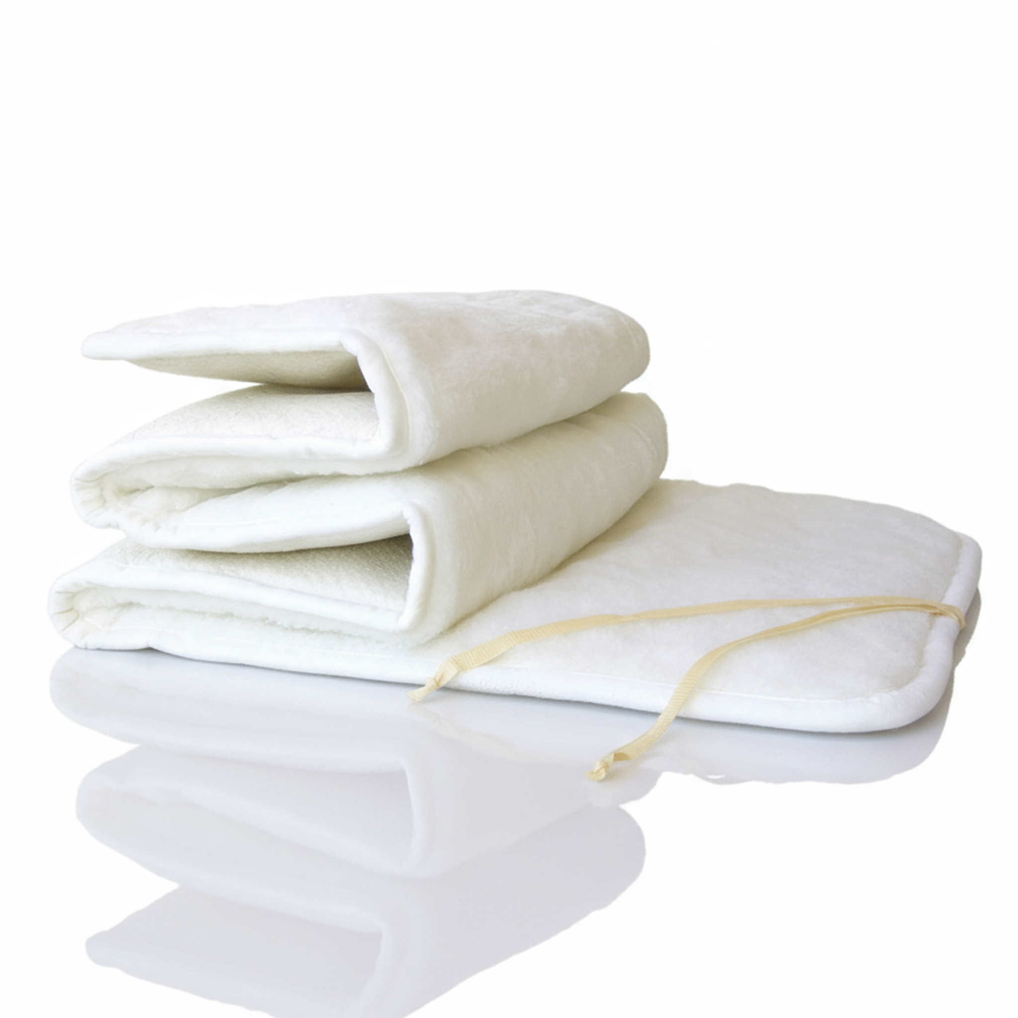 Drei weiße gefaltete Decken übereinander gestapelt