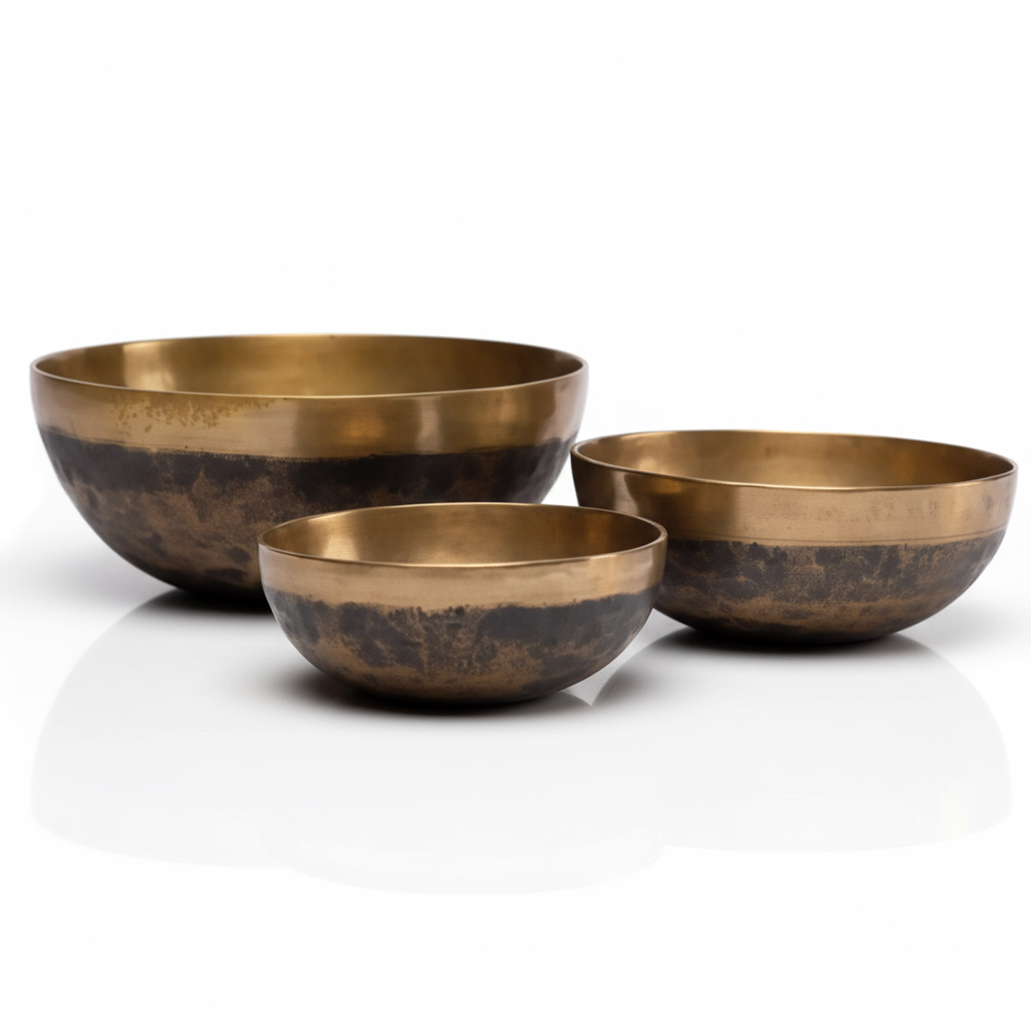 Drei goldene Metallschalen unterschiedlicher Größe auf weißem Hintergrund