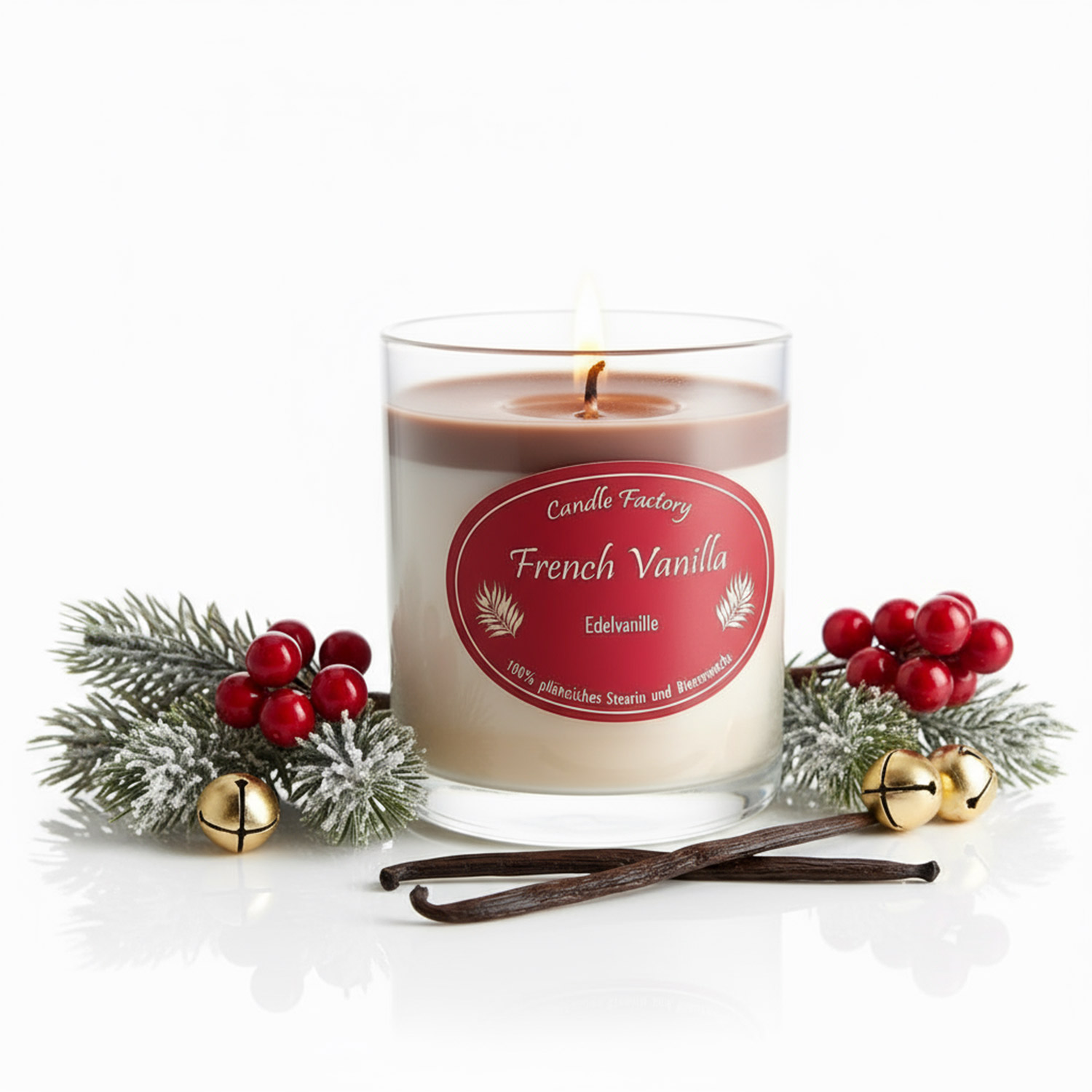 Brennende Duftkerze French Vanilla mit Deko aus Tannenzweigen, roten Beeren und goldenen Glocken.