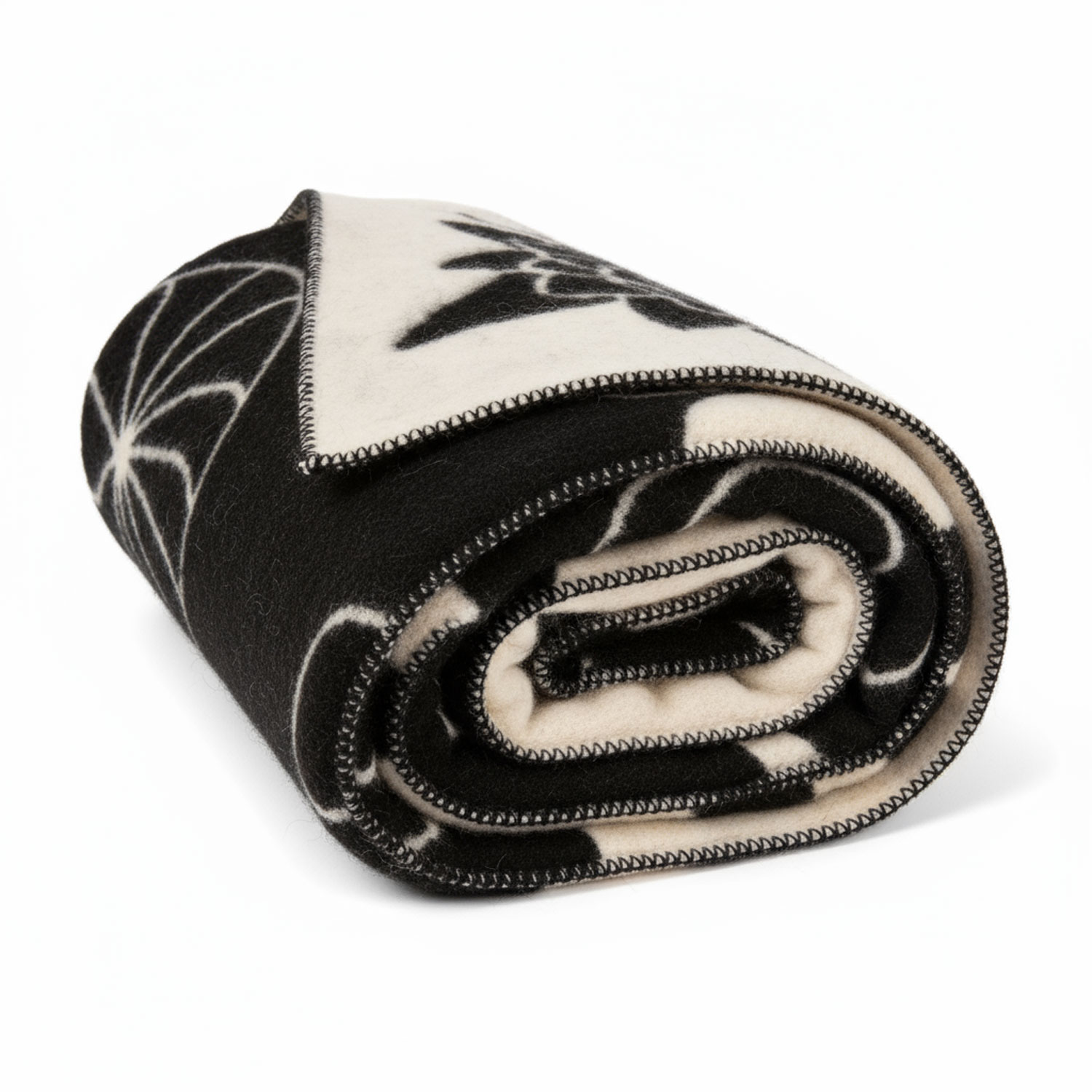 Nahaufnahme einer zusammengerollten Decke mit schwarz-weißem Muster