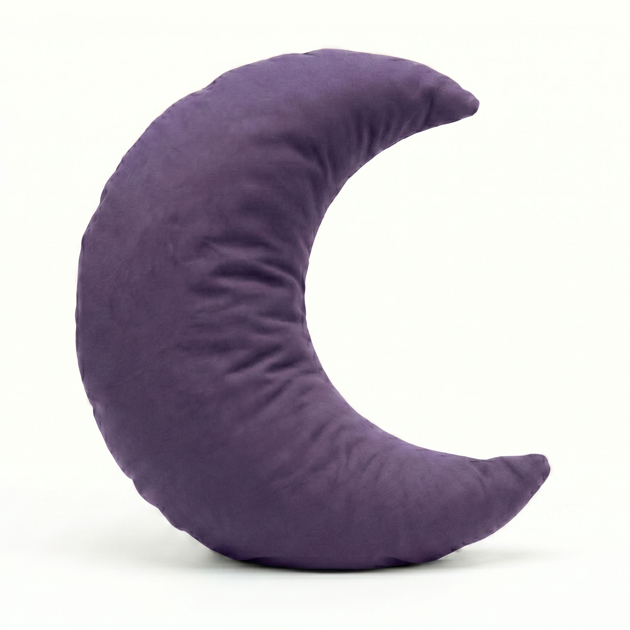 Ein lila Kissen in Form einer Mondsichel vor hellem Hintergrund