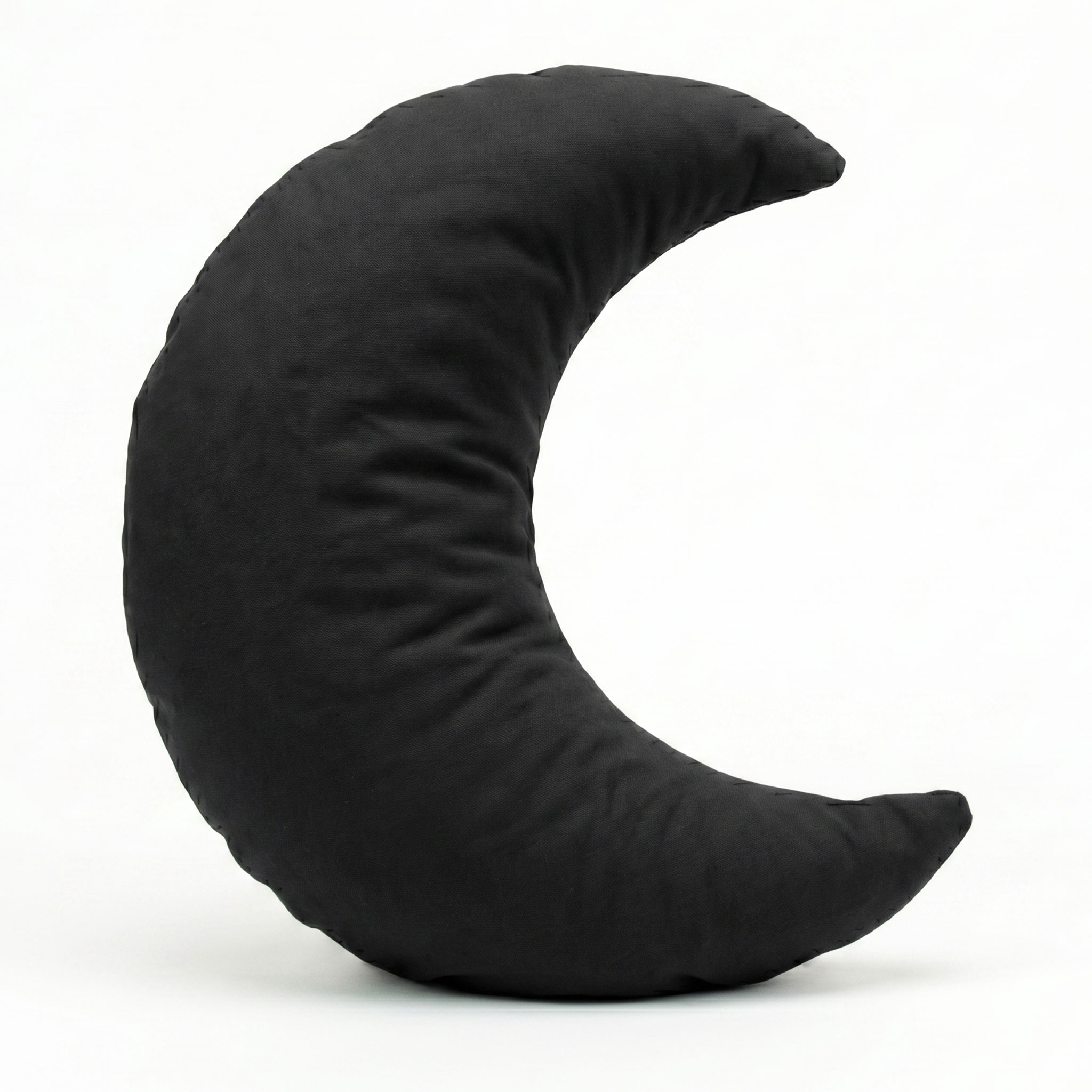 Ein schwarzes Kissen in der Form eines Halbmondes vor hellem Hintergrund