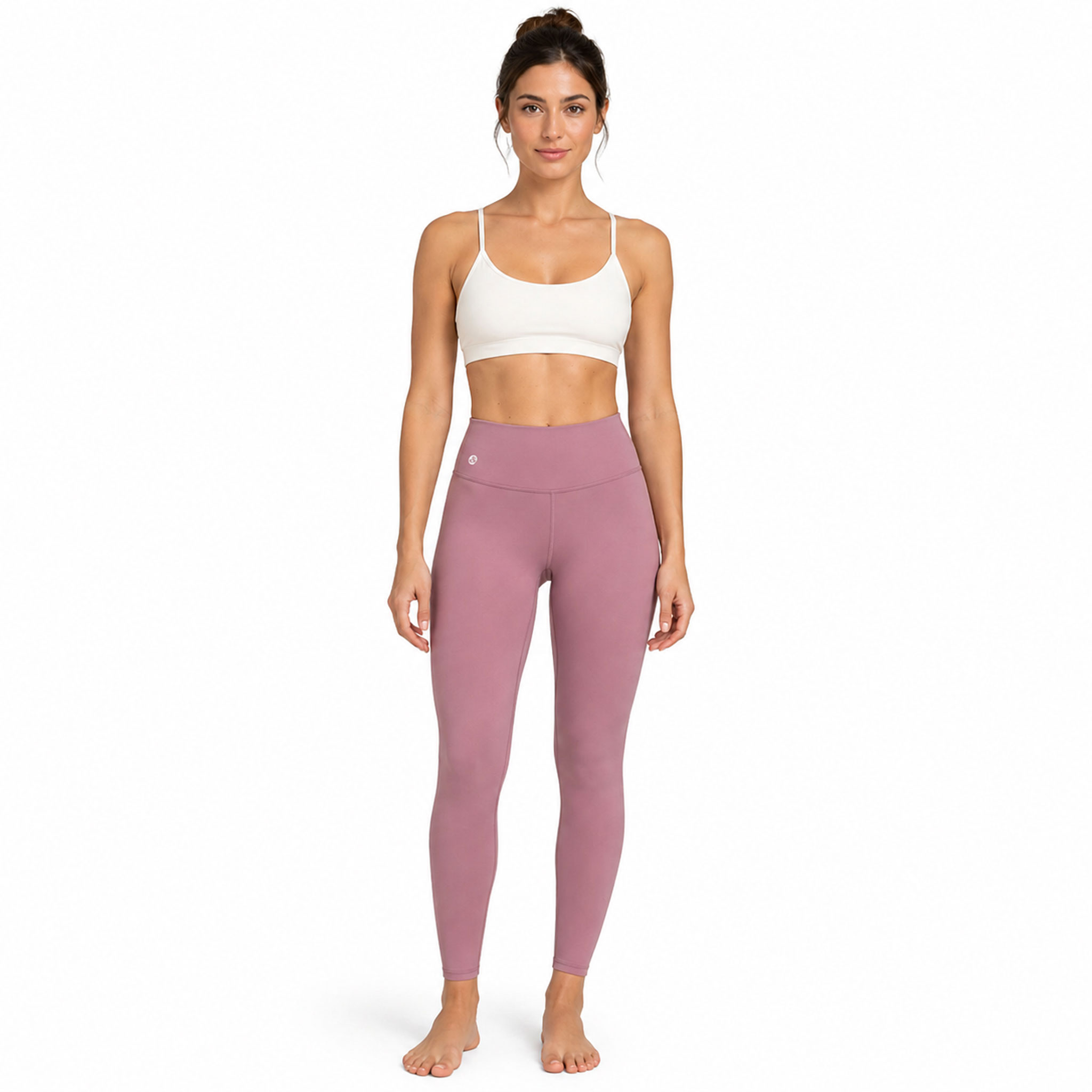 Eine Frau steht frontal und trägt einen weißen Sport-BH sowie rosafarbene Leggings.