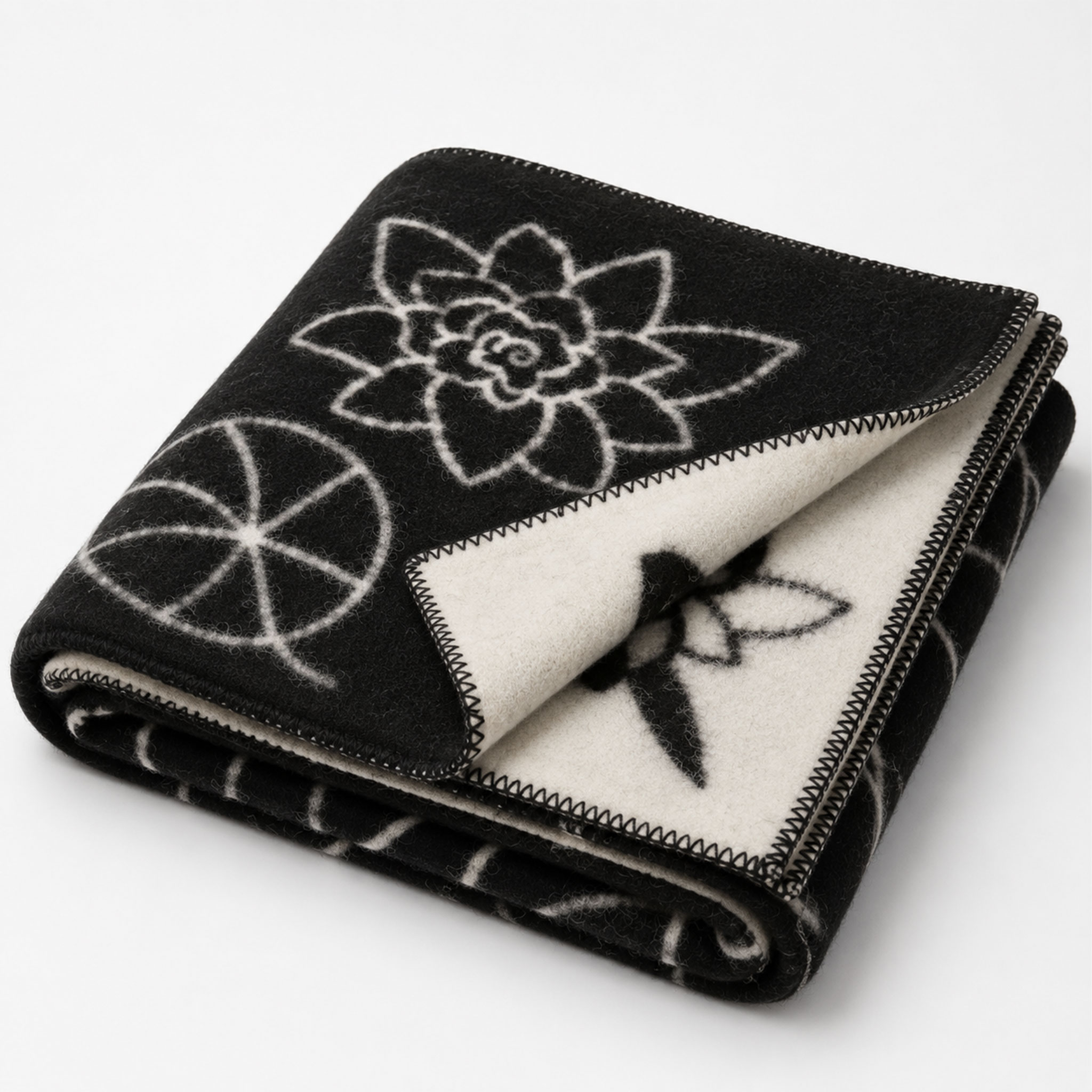 Gefaltete schwarz-weiße Decke mit floralen und geometrischen Mustern