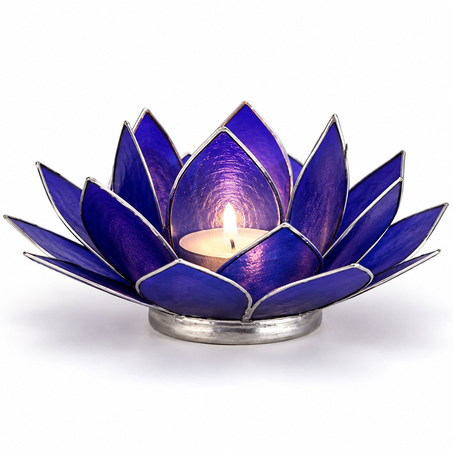 Ein blauer Kerzenhalter in Form einer Lotusblüte aus glasartigen Blütenblättern mit einem brennenden Teelicht in der Mitte vor hellem Hintergrund.