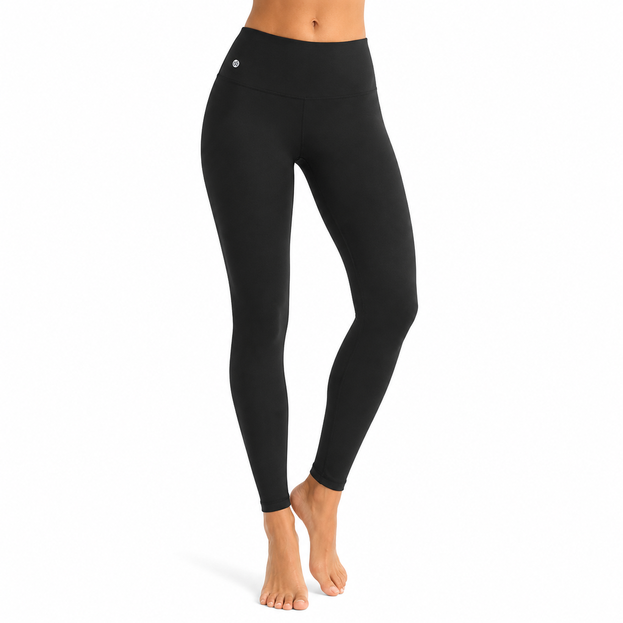 Studioaufnahme eines Models mit schwarzen High-Waist-Leggings, barfuß vor hellem Hintergrund.