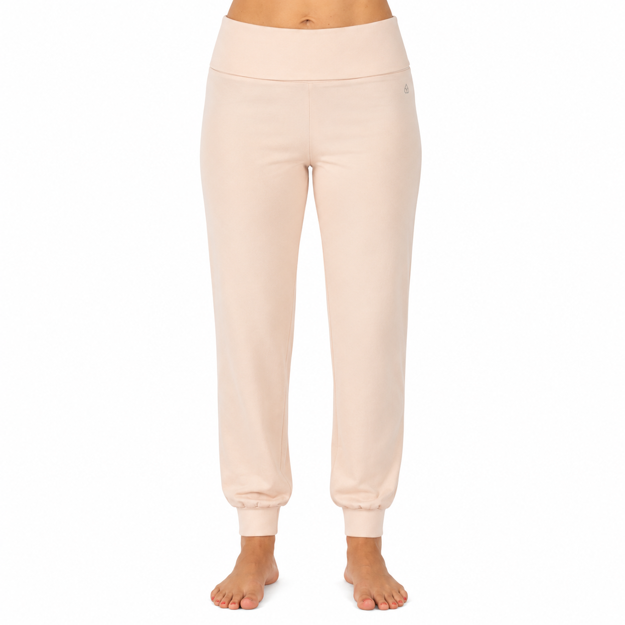 Person trägt eine hellbeige Jogginghose mit hohem Bund und Bündchen an den Knöcheln, frontal vor hellem Hintergrund fotografiert.