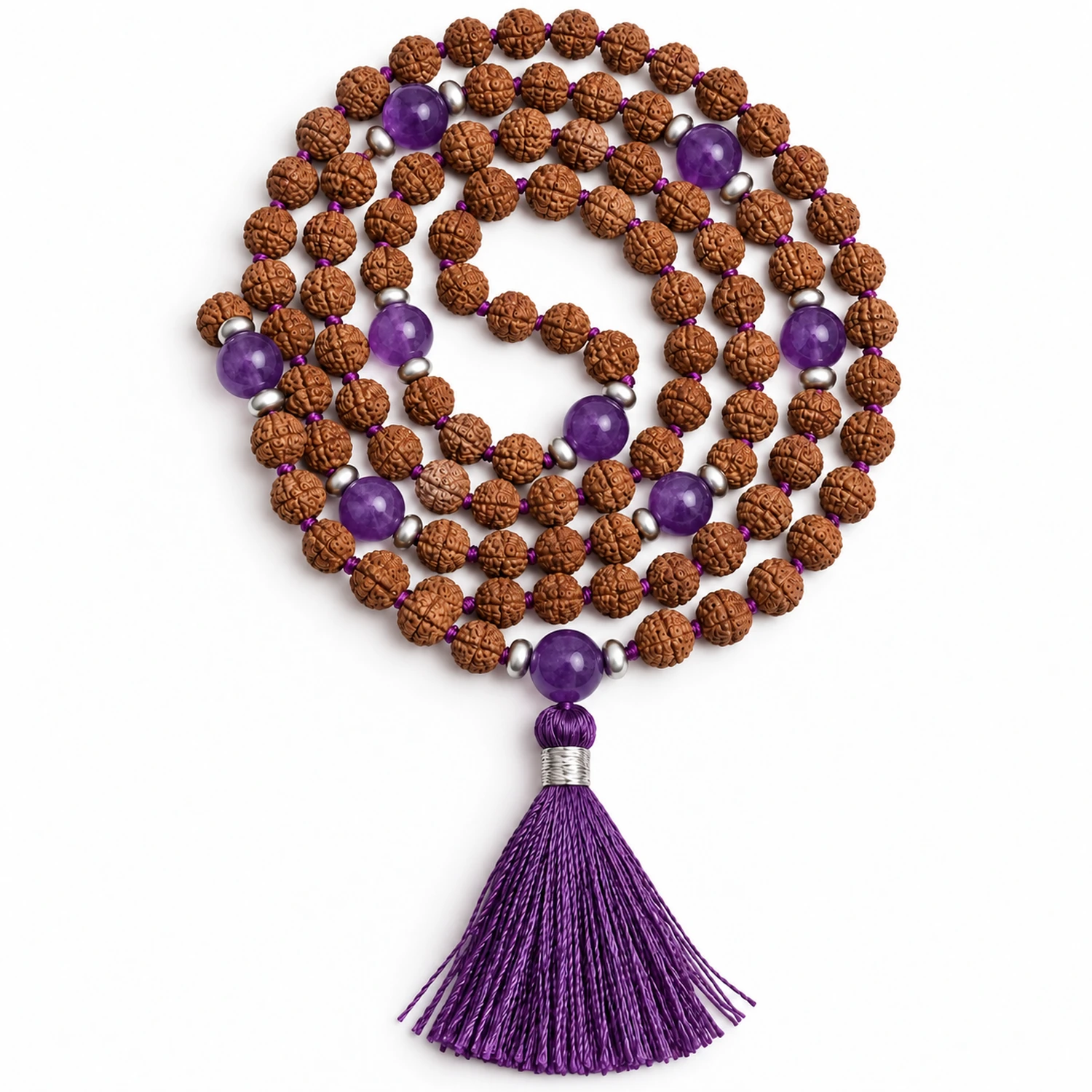 Kompakt aufgerollte Mala aus braunen Rudraksha-Samen mit violetten Amethystperlen, silberfarbenen Zwischenperlen und violetter Quaste auf weißem Hintergrund